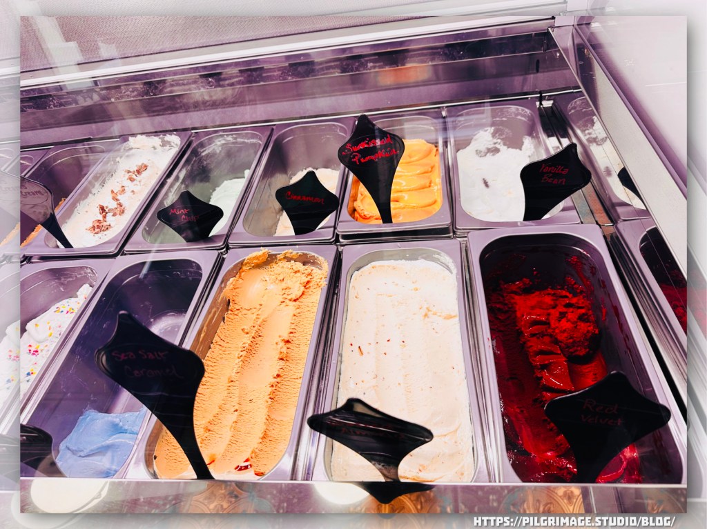 Colorful flavors of gelato in glass display window.